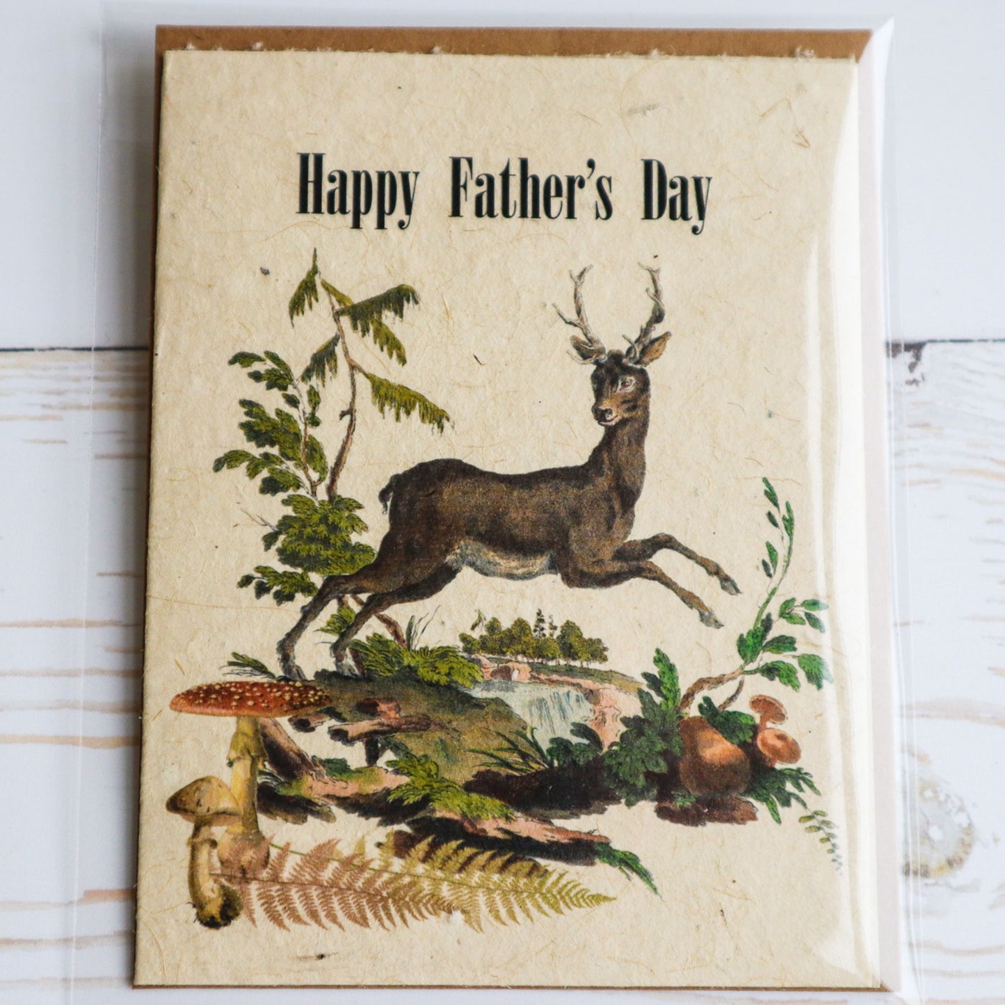 Happy Father's Day plantable flower seed paper card by Helen Jeanne Handmade with deer jumping, mushrooms, and river landscape.